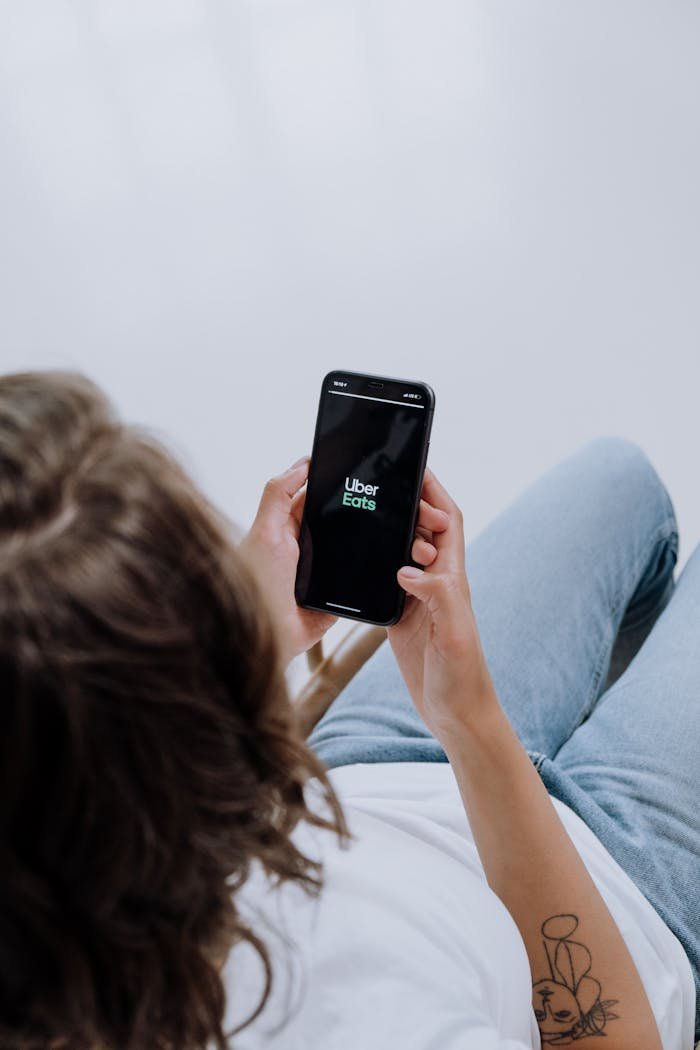 Crafting Captivating Headlines: Your awesome post title goes here Overhead view of a person using Uber Eats app on a smartphone, showcasing modern technology integration.